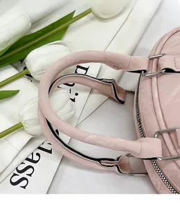 Detail of pink bow bowling bag handle with silver metal rings and stitching