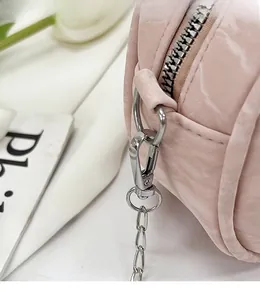 Close-up of pink textured handbag showing silver metal hook and detachable chain link
