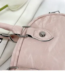 Close-up of pink leather handbag showing durable silver metal hardware and stitching details