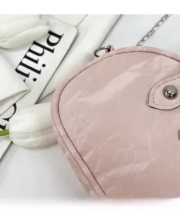 Detailed macro view of pink bowling bag with textured leather and silver chain strap
