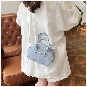 Detail of light blue bow bowling bag with glossy wrinkled leather and silver chain strap