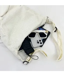 Top view of spacious beige corduroy tote showing storage for umbrella, tablet and phone