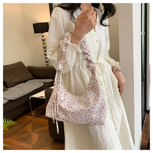 Details einer floralen Stofftasche mit Rüschengriff und Kordelzug in Wohnumgebung