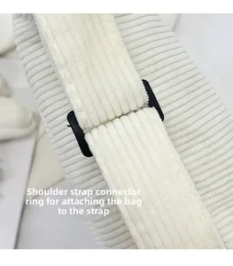 Detail of strap connector ring on cream corduroy bag showing fine stitching and texture