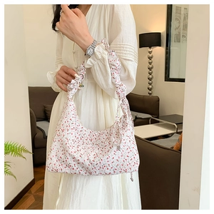 Nahaufnahme der floralen Nylontasche mit Rüschengurt und roten Blumenmustern