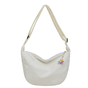 White corduroy crescent crossbody bag with colorful bear charm and adjustable strap
