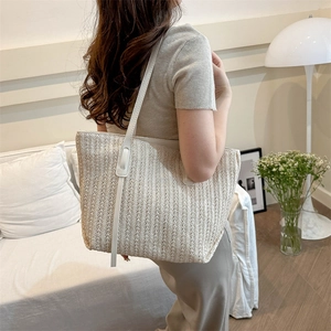 Large cream woven straw tote bag with white leather straps for summer beach or commute
