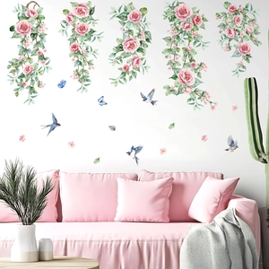 Pink floral vine wall stickers with blue birds over a sofa in a modern living room