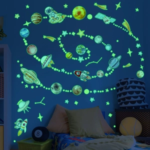 Luminous space wall stickers showing glowing planets and rockets in dark bedroom