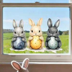 Detail of Easter bunny window clings with colorful eggs on a glass surface with nature view