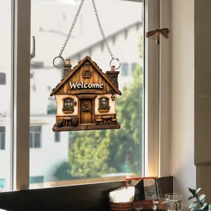 Detailed view of 2D flat acrylic cabin welcome sign hanging on a silver chain by a window