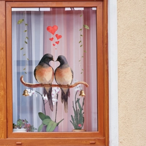 Détail de stickers oiseaux et cœurs sur vitre avec motifs de cloches dorées