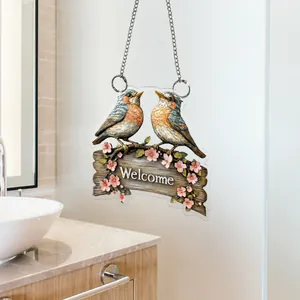 Close-up of a 2D flat acrylic welcome sign featuring two birds on flowering branches