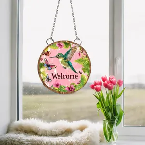 Close-up of a 2D acrylic floral welcome sign with hummingbirds and a metal hanging chain