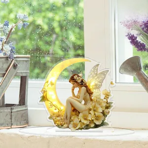 Detailed 2D acrylic fairy ornament on moon with warm yellow tones and transparent base