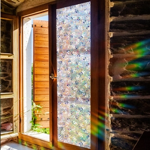 Rainbow prism effect detail on floral mosaic static window film under sunlight