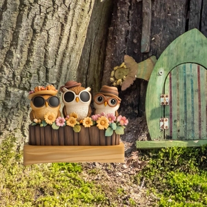 Three cute resin owls on a fence with flowers, perfect for miniature garden decoration