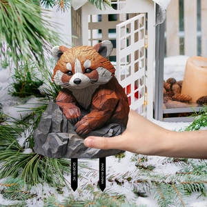 Detail of red panda garden stake with wood carving texture and metal soil support rods