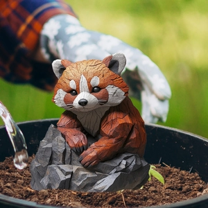 Macro detail of red panda garden stake with wood carving texture in a flower pot