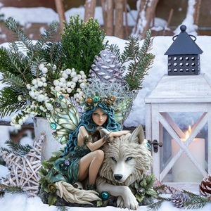 Detail of blue-haired fairy figurine with white wolf in a snowy garden setting