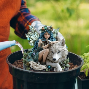 Garden fairy statue with blue wings and white wolf figurine in a potting plant decor