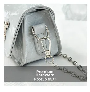 Detail of high-quality silver hardware and grey marble leather texture on mini saddle bag