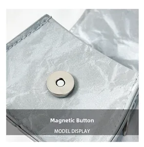 Macro detail of silver wrinkled saddle bag featuring a circular magnetic snap closure