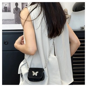 Mini black crossbody saddle bag featuring silver butterfly chain and velvet finish
