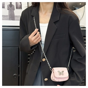 Close-up of light pink mini saddle bag with silver butterfly buckle and chain strap