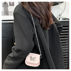Detailed close-up of a mini pink saddle bag with a silver butterfly chain and strap