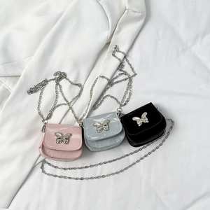 Mini saddle bags with butterfly chains in pink, silver, and black on a white background