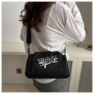Détail d'un sac bandoulière noir en nylon avec double zip et logo Sport blanc imprimé
