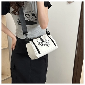 Selfie miroir montrant la taille du sac à bandoulière blanc cylindrique à sangle noire