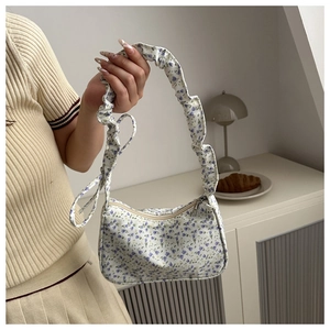 Detail of floral underarm bag with purple flower pattern and ruffled scrunchie strap
