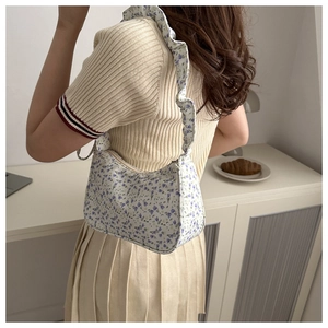 Detailed shot of floral armpit bag with ruffled shoulder strap on model back view