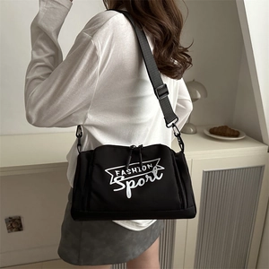 Sac bandoulière sport noir en nylon avec imprimé, porté par un mannequin en intérieur