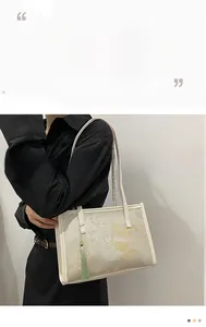 Detail of Chinese style floral embroidery and light green tassel on the tote bag