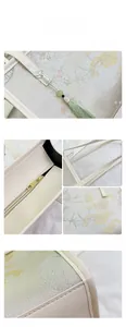 Detail view of floral embroidery on Chinese style tote with green tassel and gold zipper