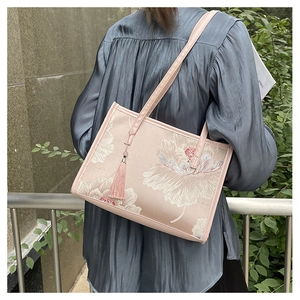 Detail of pink embroidered peony tote bag with tassels and Chinese style floral patterns