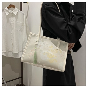 Detailed embroidery of flowers and clouds on a beige Chinese style tote bag