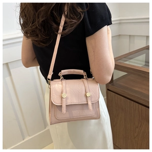 Détail du sac à bandoulière en cuir plissé rose clair avec boucle en métal doré