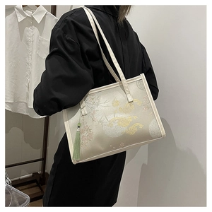 Detail of embroidered floral tote bag with cloud patterns and long green silk tassel