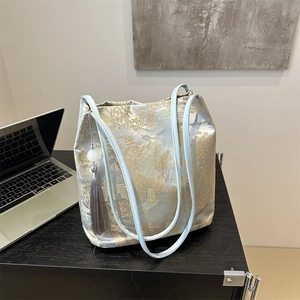 Casual large capacity tote bucket bag with traditional pattern and tassel on desk