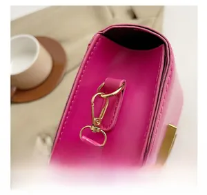 Détail du sac à main rose avec des ferrures en métal doré et des coutures fines