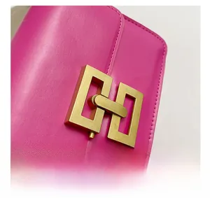 Détail de la boucle dorée mate sur un sac bandoulière en cuir rose fuchsia