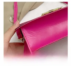 Détail de la couture précise et des garnitures dorées sur le sac à bandoulière en cuir