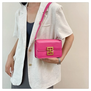 Détail du sac bandoulière rose fuchsia avec une boucle géométrique dorée élégante