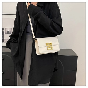 Détail du sac bandoulière en cuir verni blanc avec fermoir géométrique doré chic