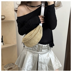 Close-up of crescent woven straw chest bag with adjustable strap and gold zipper