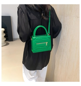 Detail showing bright green crocodile pattern PU leather crossbody bag with gold zipper
